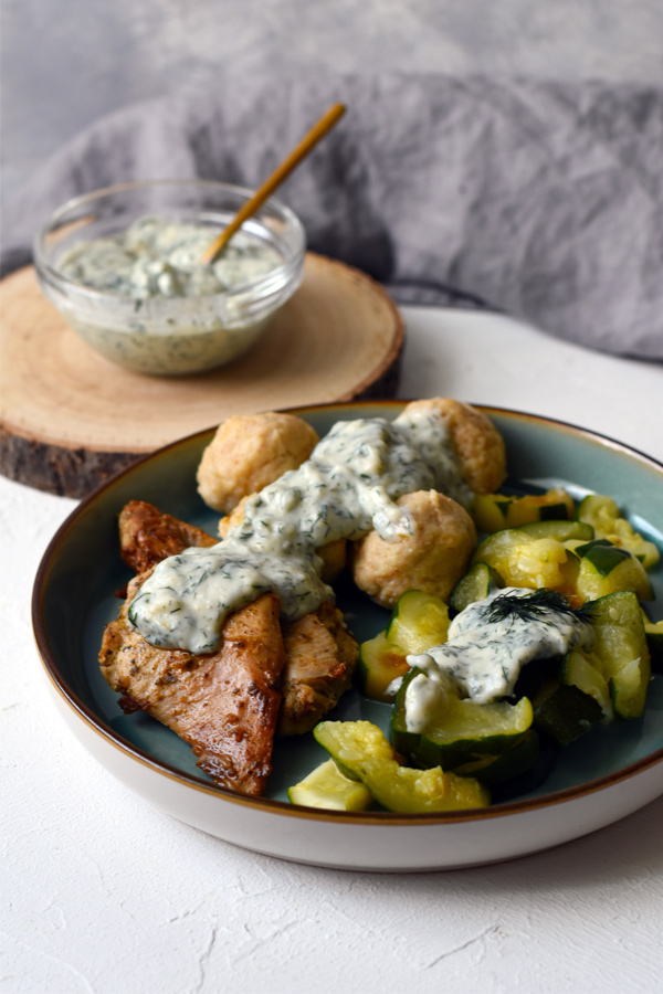Dill sauce with potato dumplings, zucchini, and roasted meat